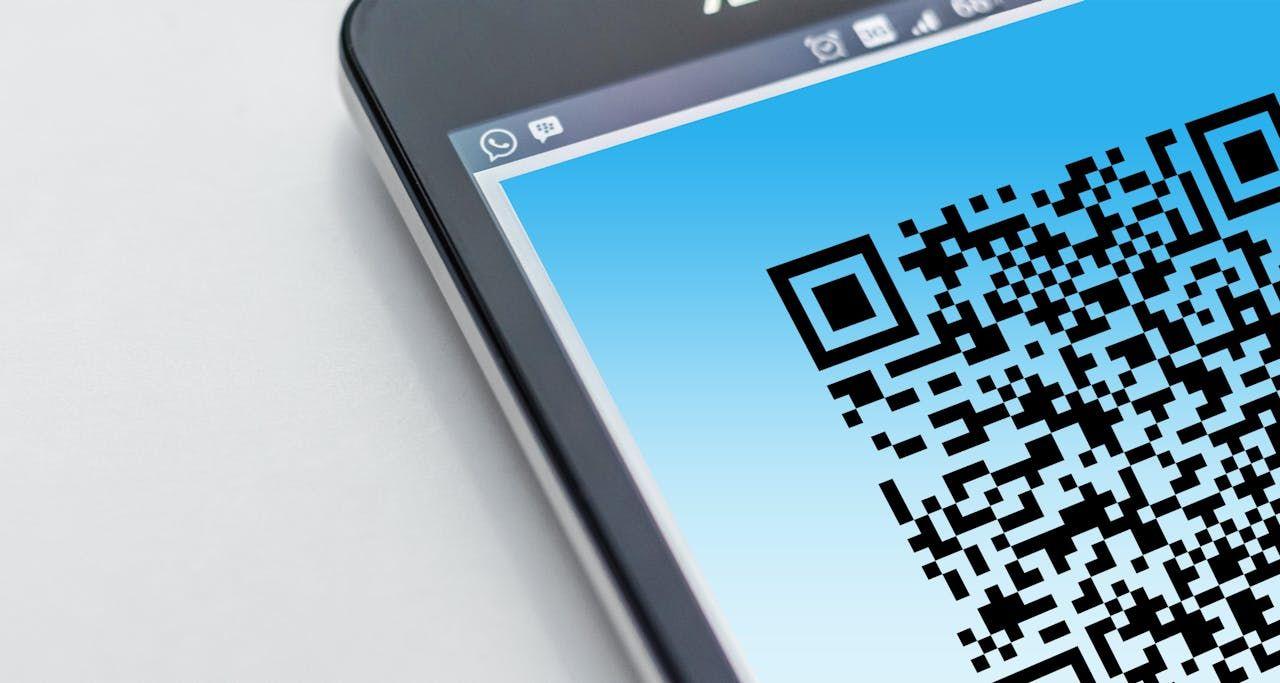 A smartphone screen displays a black QR code on a bright blue background.